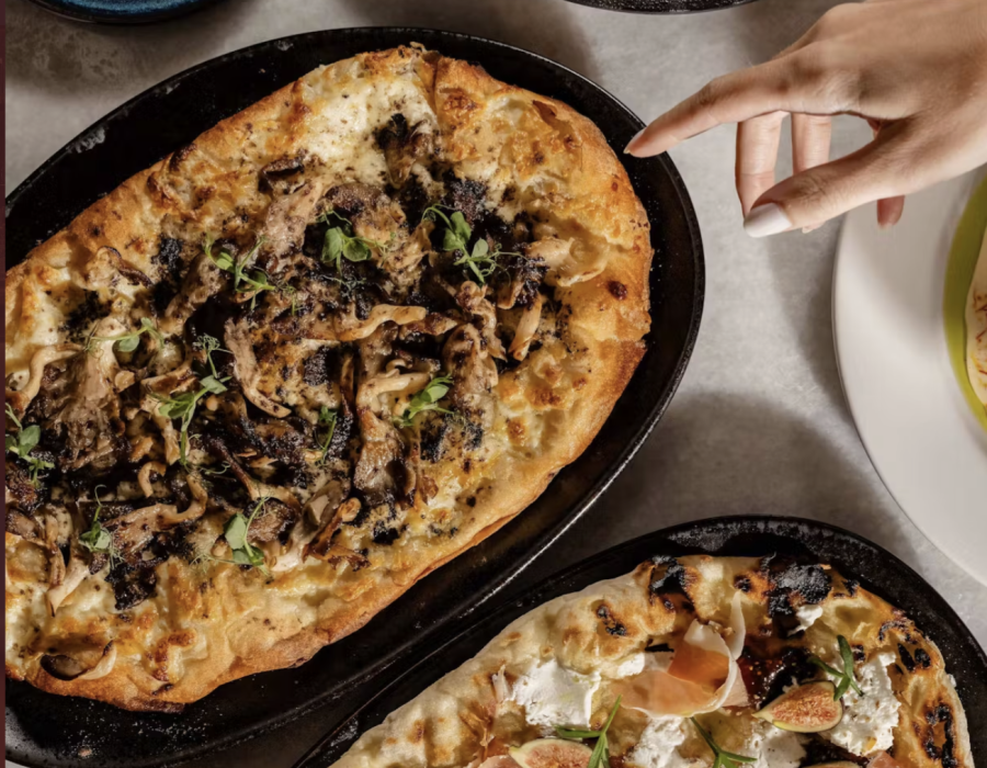 pizza flatbread with hand reaching out to take a piece